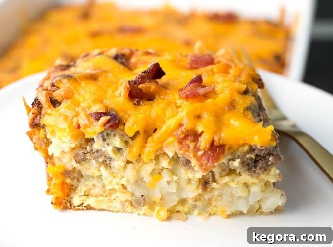 A perfectly portioned slice of Tater Tot Breakfast Casserole on a pristine white plate, ready to be enjoyed.