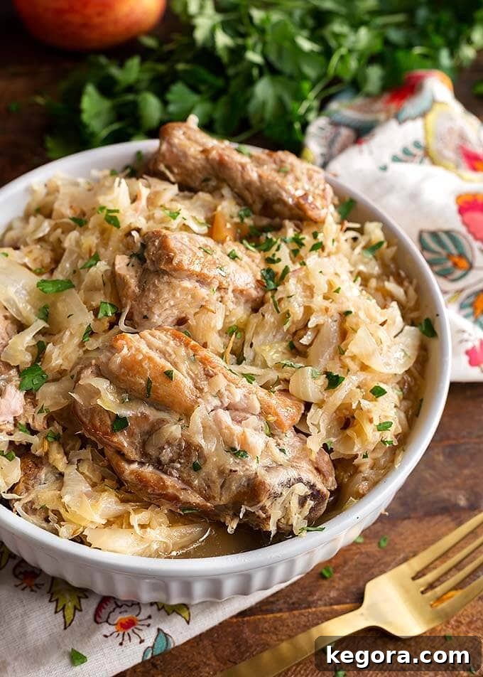 A bowl of slow-cooked pork and sauerkraut, rich in color and texture, served with a golden fork, inviting you to taste this hearty German meal.