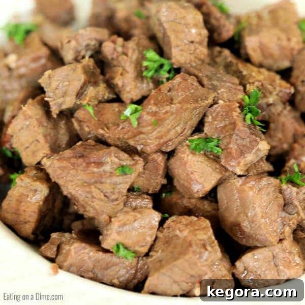 Tender and flavorful Instant Pot Steak Bites served in a white bowl, highlighted by the 'Eating on a Dime' logo.