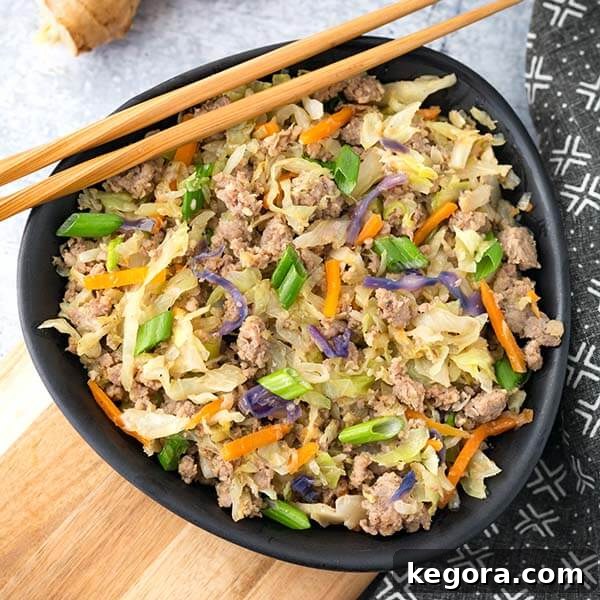 Instant Pot Egg Roll in a Bowl served in a black bowl with bamboo chopsticks, showcasing a vibrant and healthy one-pot meal.