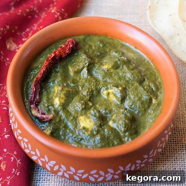 A serving of authentic Palak Paneer in an orange bowl with a delicate white pattern, showcasing a nutritious and flavorful Indian dish.