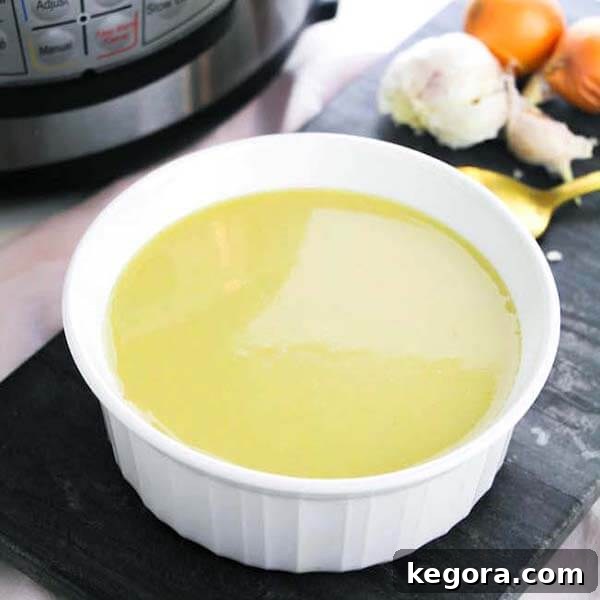 A comforting bowl of Keto Instant Pot Asparagus Soup in a white bowl, positioned in front of a pressure cooker, highlighting its freshness.