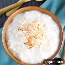 Coconut Rice Pudding in a brown bowl topped with toasted coconut.