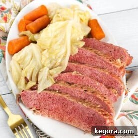 Sliced Corned Beef and Cabbage with carrots on an oblong white plate