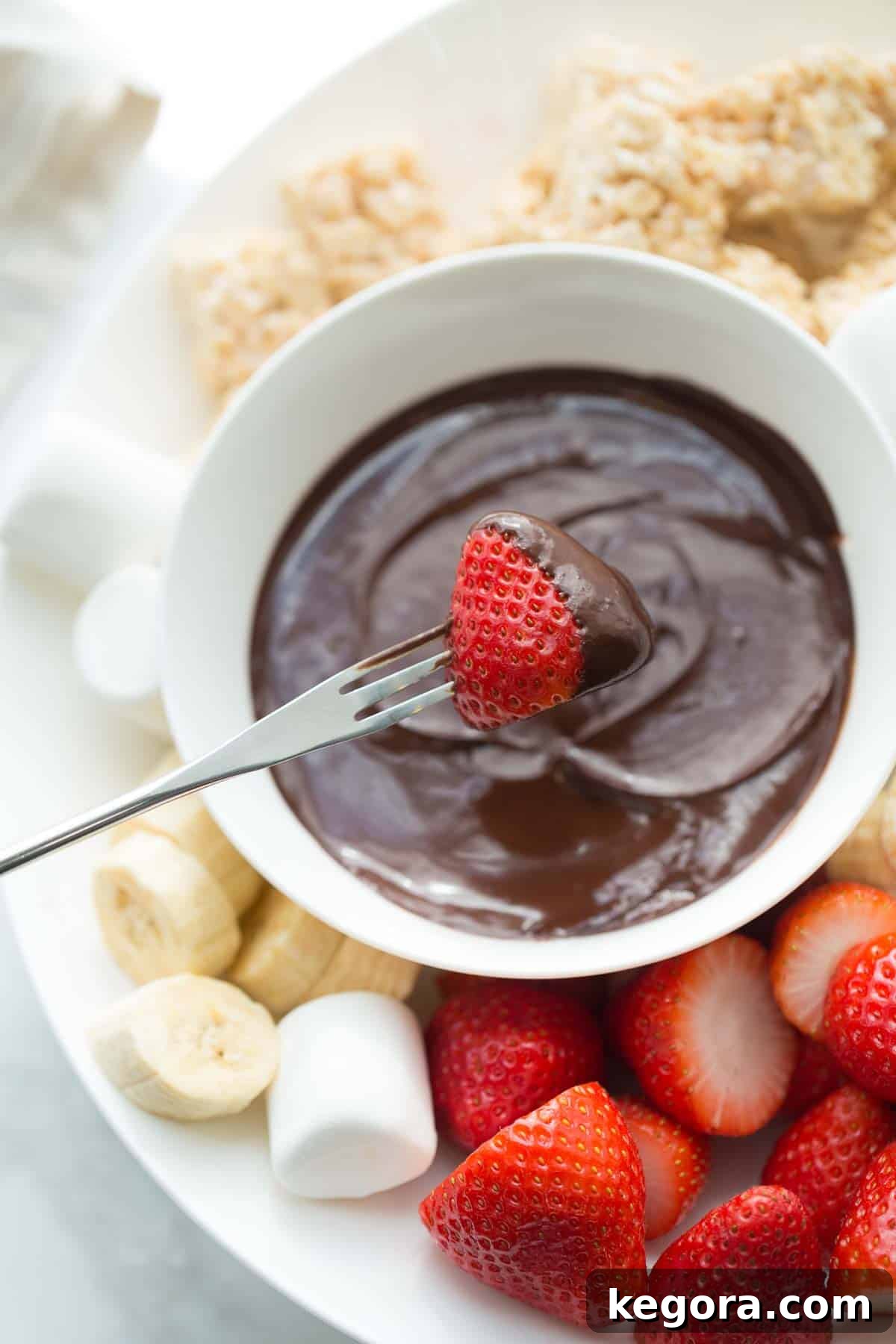 strawberry being dipped into chocolate fondue