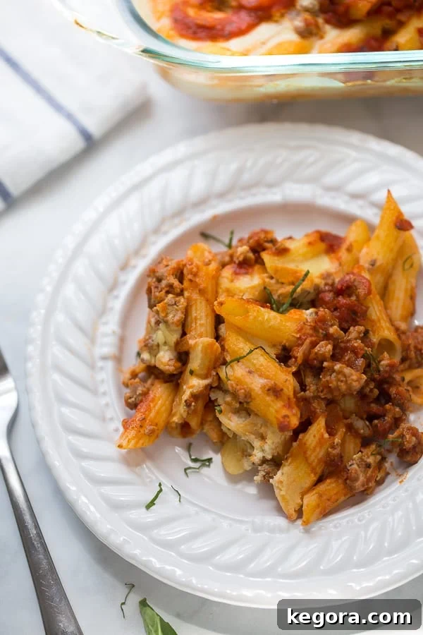 Creamy Vegan Gluten-Free Baked Ziti 3 Close-up of baked ziti with rich tomato sauce and creamy cashew ricotta, garnished with fresh herbs.