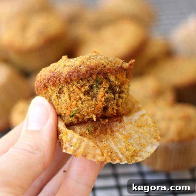 Tiny Taster Carrot Zucchini Muffins 2 hand holding bite size zucchini muffin