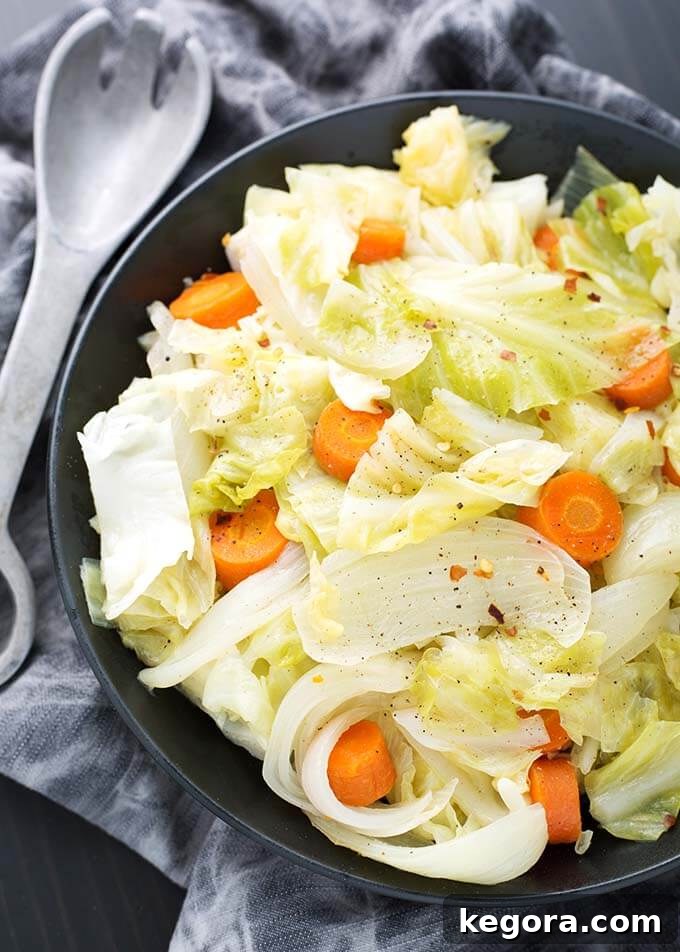 A beautifully cooked Instant Pot Cabbage Side Dish in a black bowl, accompanied by a silver fork on a gray napkin, highlighting its rustic elegance.