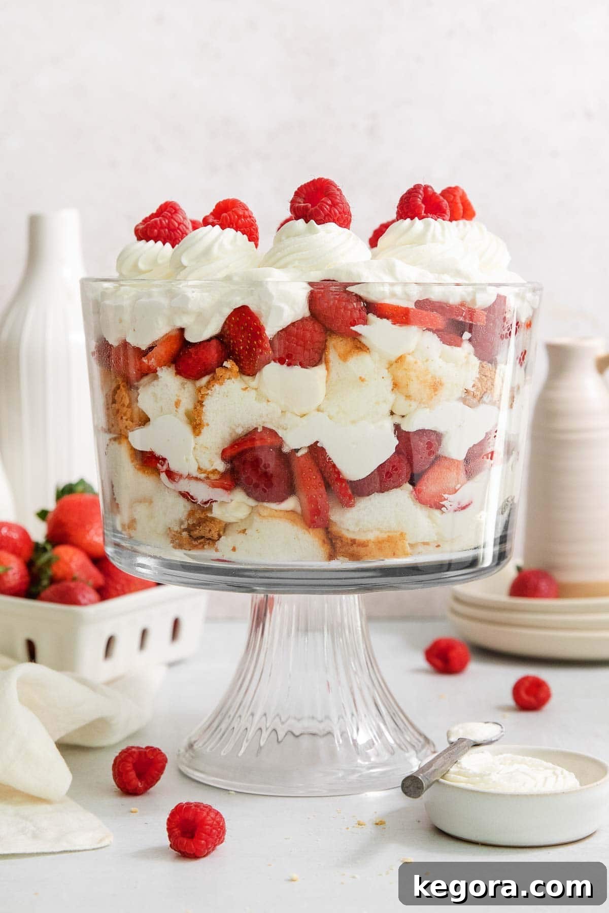 Luscious Gluten-Free Strawberry Cream Cheese Trifle 3 Layers of gluten-free angel food cake, cream cheese, fresh strawberries, and whipped cream beautifully arranged in a clear glass trifle dish, ready to be served.