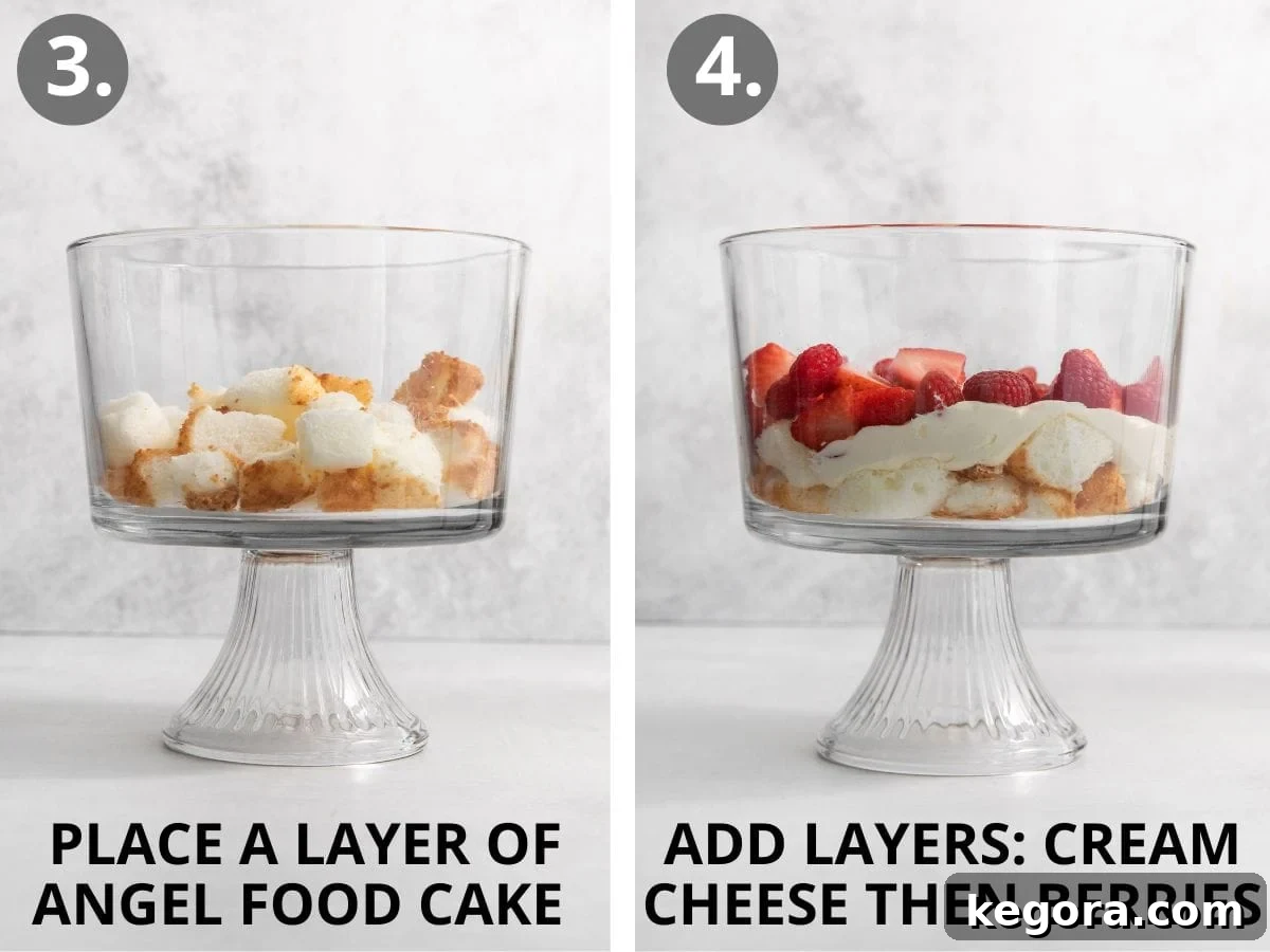 Luscious Gluten-Free Strawberry Cream Cheese Trifle 7 Mid-assembly of the trifle, showcasing the layers of angel food cake pieces, followed by the cream cheese mixture, and then a generous layer of fresh berries.