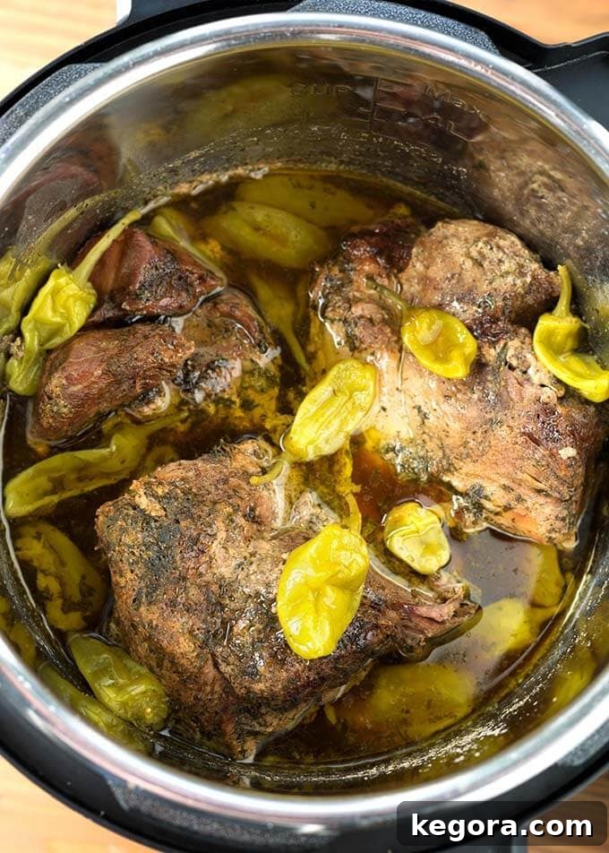 Mississippi Pork cooking in an Instant Pot pressure cooker, capturing the steam and rich liquid