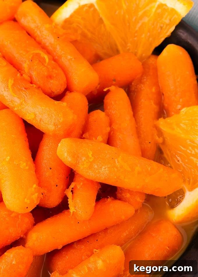 Close-up view of perfectly glazed Instant Pot Orange Maple Carrots, showing their tender texture and the glistening maple-orange sauce.