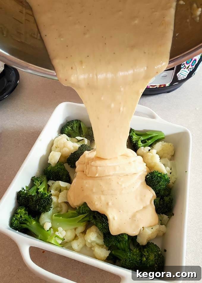 Quick & Easy Instant Pot Broccoli Cauliflower Cheese Bake 6 broccoli and cauliflower in a white baking dish with cheese sauce pouring over them