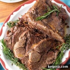 Leg of Lamb on red bordered plate garnished with rosemary