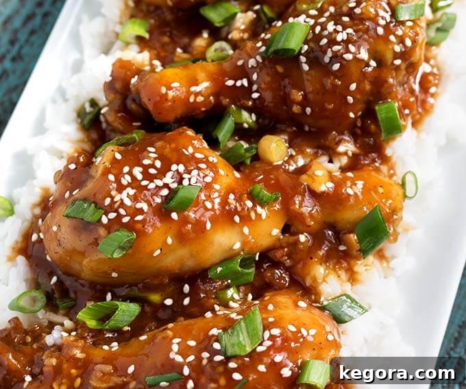 Sweet and Sticky Slow Cooker Honey Garlic Chicken 4 Closeup of Honey Garlic Chicken over rice on white platter