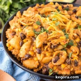 Loaded Taco Pasta on a black plate with a spoon