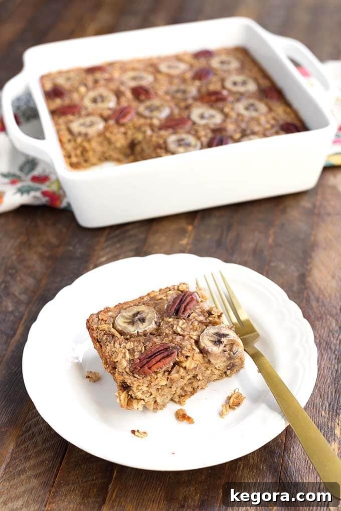 Warm Banana Bread Oatmeal Bake 3 Slice of Banana Bread Baked Oatmeal on white plate with fork in front of white baking dish