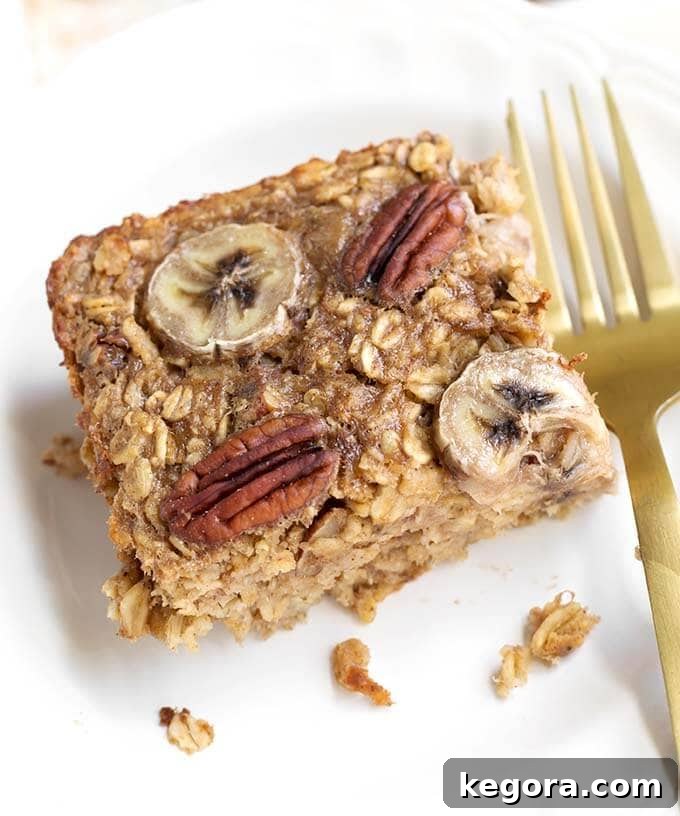Warm Banana Bread Oatmeal Bake 4 close up of Baked Oatmeal on white dish with gold fork