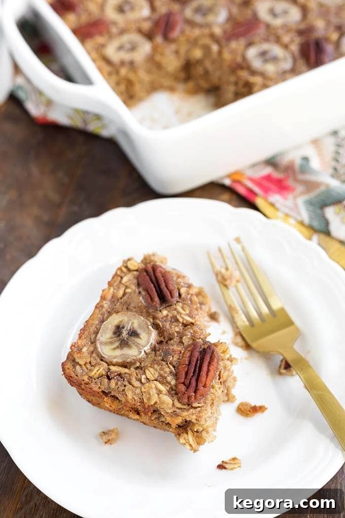 Warm Banana Bread Oatmeal Bake 5 Partially eaten slice of Baked Oatmeal on white dish with gold fork