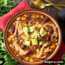 Chicken Taco Soup in a brown bowl on a red napkin next to fresh cilantro