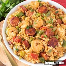 Jambalaya in a white bowl on a wooden board