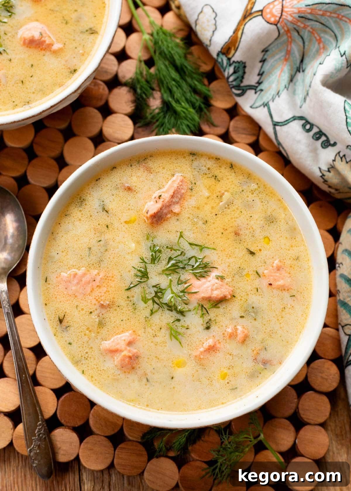 Artisan Salmon Chowder 2 A generous serving of creamy Salmon Chowder in a pristine white bowl, garnished with fresh dill.