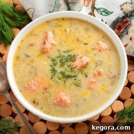 A close-up of creamy Salmon Chowder in a white bowl, garnished with fresh dill.