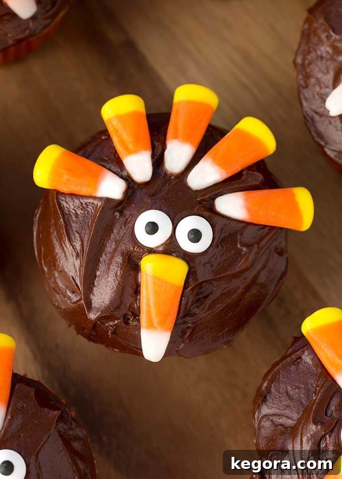 Candy Corn Turkeys: Thanksgiving Cupcake Delights 3 Closeup of a single Candy Corn Turkey Thanksgiving Cupcake on a wooden board, highlighting the intricate candy corn feathers and edible googly eyes