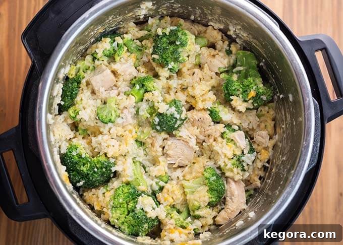 Top-down view of creamy Instant Pot Chicken Broccoli Rice Casserole with melted cheese, inside the Instant Pot before serving
