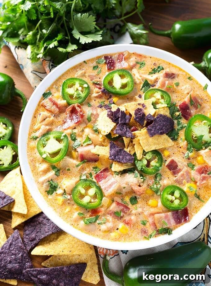 Popper Power Chili 3 Top view of Jalapeño Popper Chicken Chili in white bowl next to chips and sliced Jalapenos