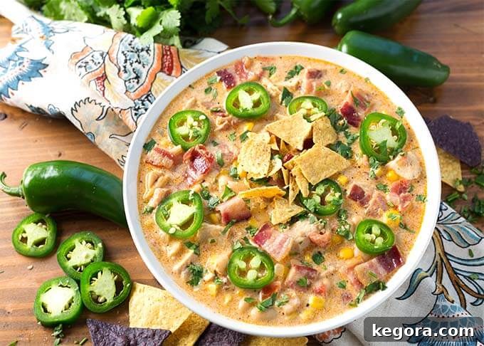 Popper Power Chili 4 Top view of Jalapeño Popper Chicken Chili in white bowl next to sliced jalapenos and tortilla chips