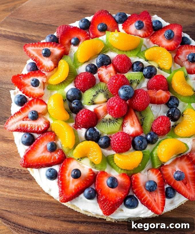 Fresh Fruit Pizza on a rustic wooden surface, showcasing its vibrant colors
