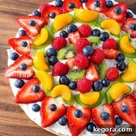 Fresh Fruit Pizza on wooden board with vibrant fruit