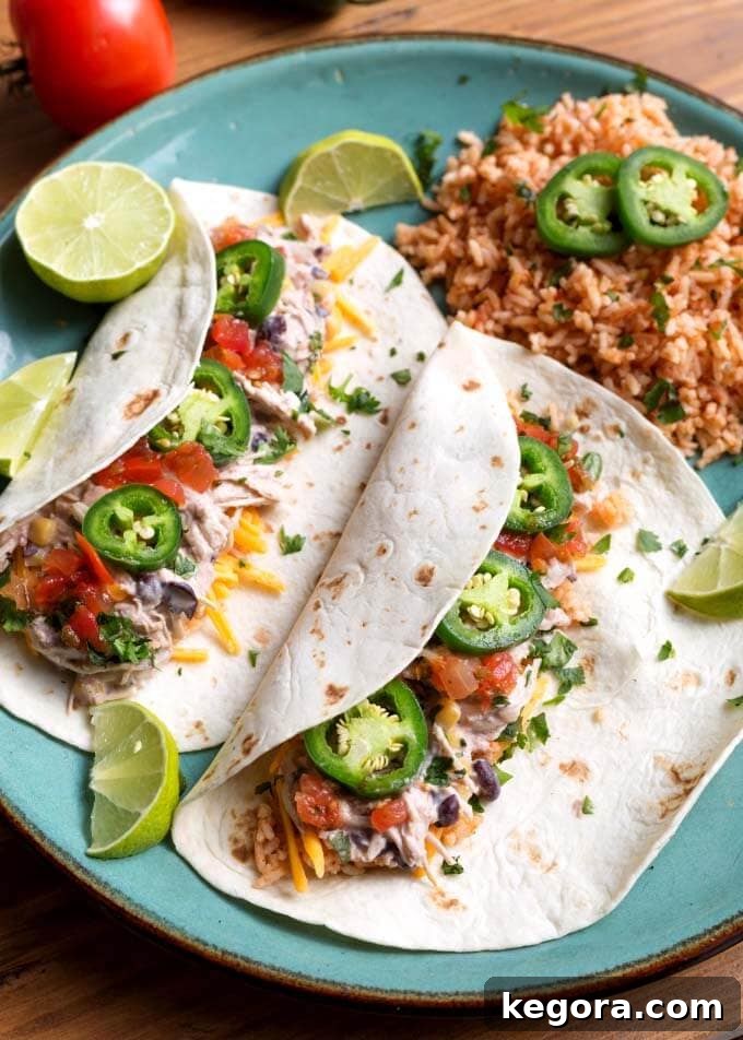 Mexican Shredded Chicken served on two flour tortillas on a blue plate, ready to eat