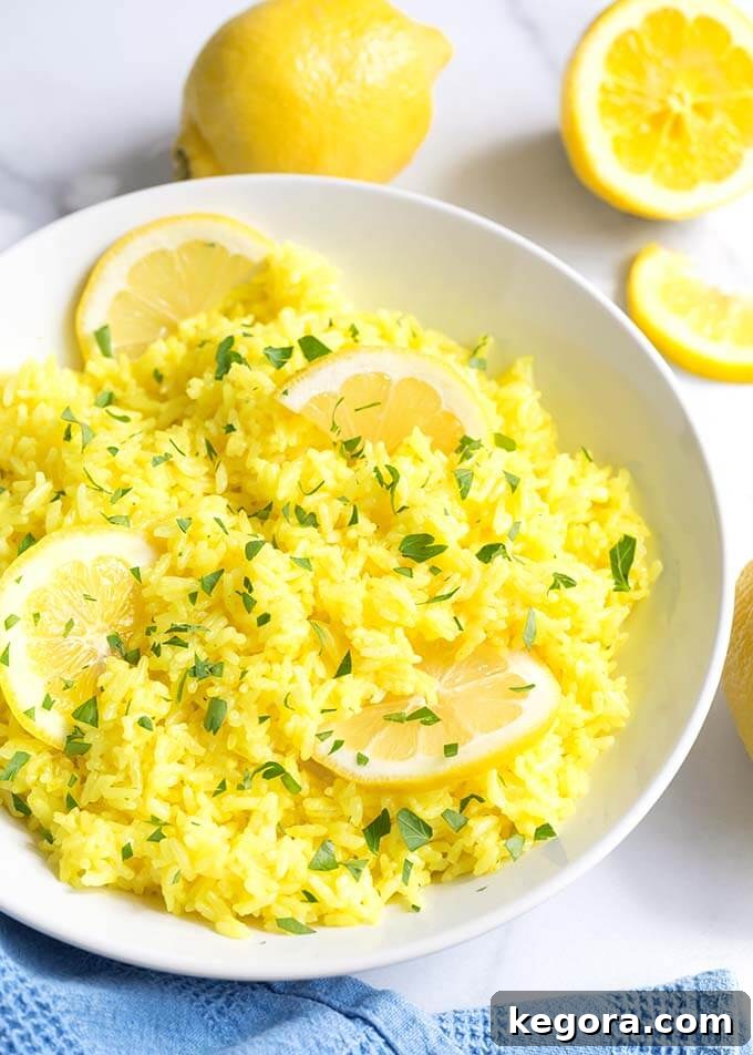 Lemon Rice in a white bowl with sliced lemons