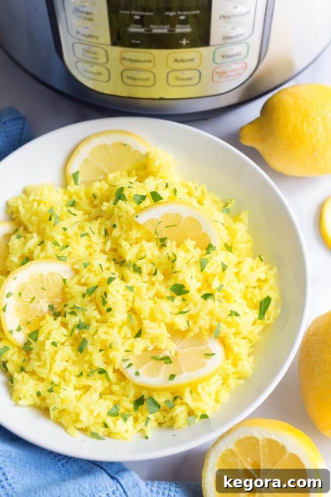 Lemon Rice in white bowl with sliced lemons in front of pressure cooker