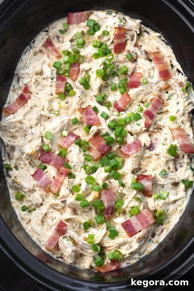 Slow Cooker Cheesy Bacon Ranch Chicken 3 Crack Chicken simmering in a slow cooker, showcasing its rich texture