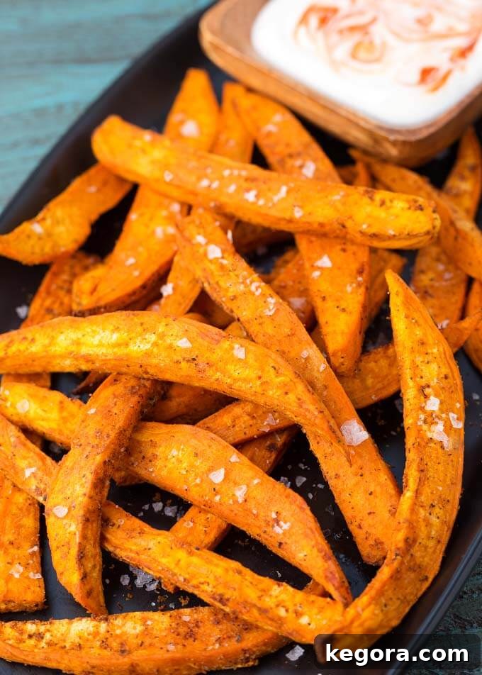 Air Fryer Sweet Potato Fries on black plate with dipping sauce