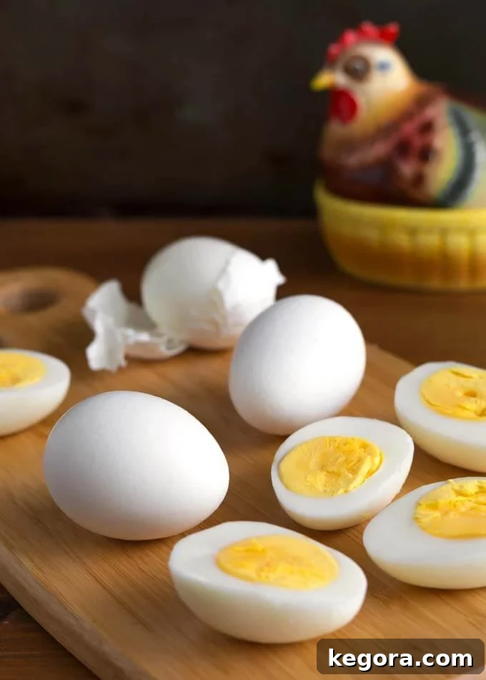 Perfect Air Fryer Boiled Eggs 2 Air Fryer Boiled Eggs on wooden board in front of ceramic chicken