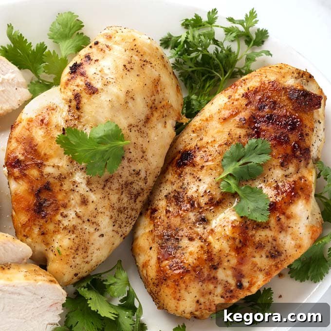Juicy Air Fryer Chicken Breasts 4 Close up of Air Fryer Chicken Breasts on white plate garnished with fresh parsley