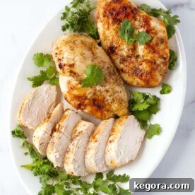 Juicy Air Fryer Chicken Breasts 6 Air Fryer Chicken Breasts on white plate garnished with fresh parsley