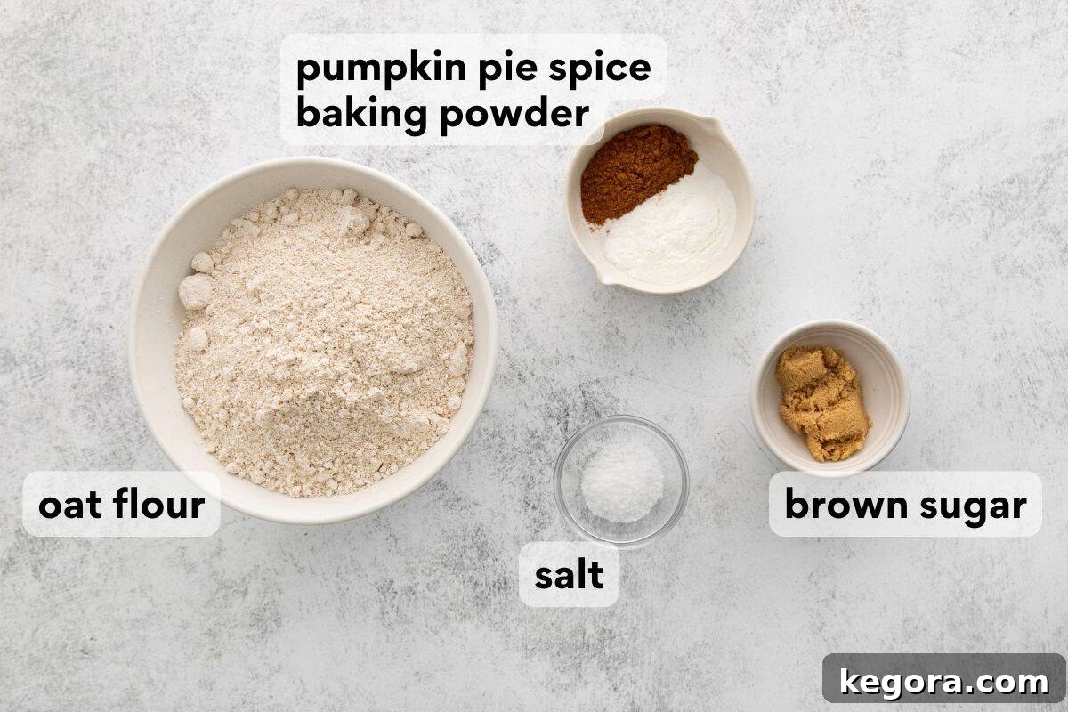 Spiced Oat Flour Pumpkin Pancakes 4 Carefully measured dry ingredients for pumpkin pancakes, including oat flour, brown sugar, baking powder, pumpkin pie spice, and kosher salt, neatly arranged on a kitchen counter.