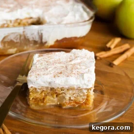 Spiced Caramel Apple Poke Cake 9 Caramel Apple Poke Cake slice on a glass plate, showcasing layers and caramel.