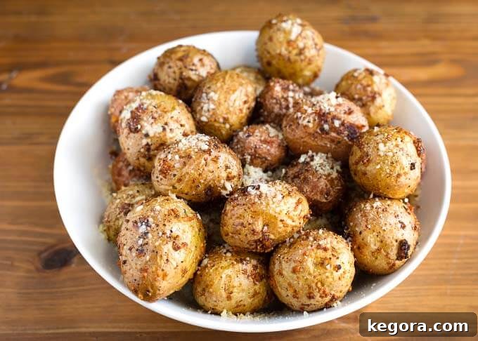A white bowl filled with a generous serving of Air Fryer Garlic Parmesan Potatoes, ready to be enjoyed.