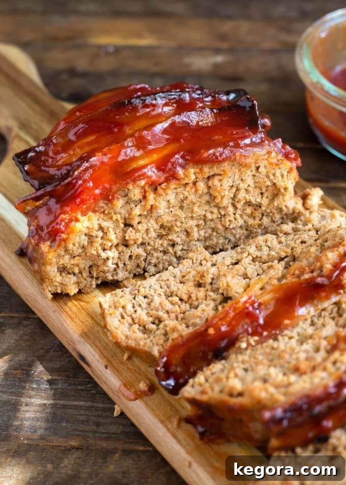 Close up view of perfectly cooked, sliced Air Fryer Turkey Meatloaf, showing its moist texture and savory topping