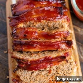 Sliced Air Fryer Turkey Meatloaf on wooden board, garnished and ready to serve
