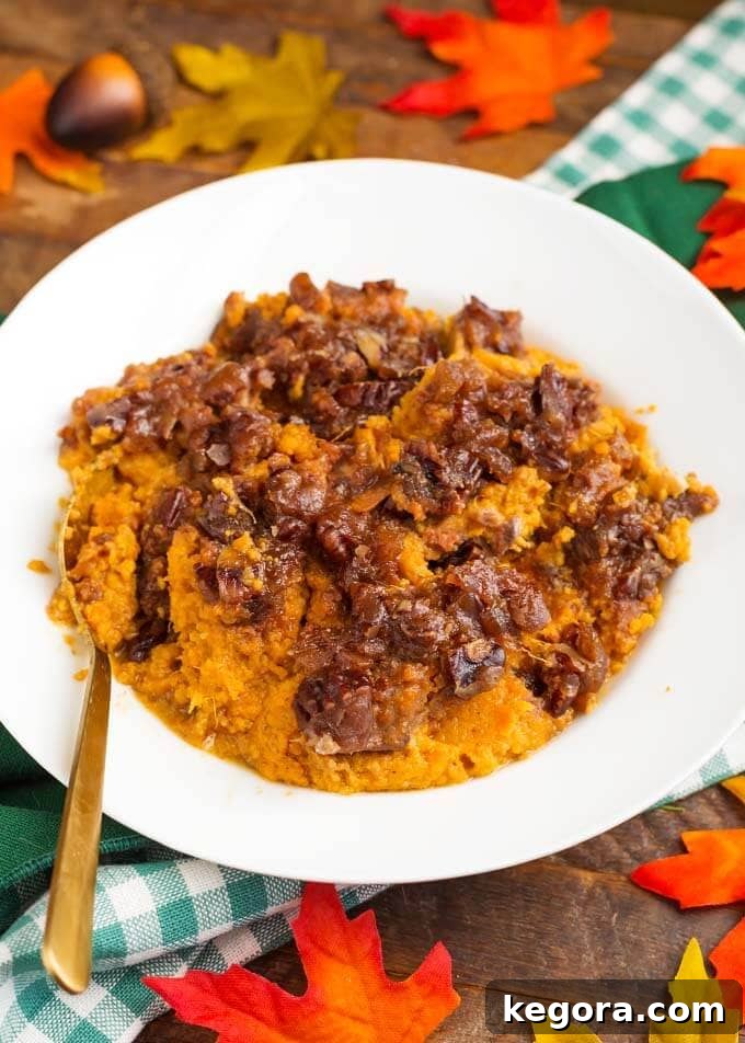 Velvety Slow Cooker Sweet Potatoes 2 Slow Cooker Creamy Sweet Potatoes Casserole served on a white plate with a golden spoon, ready for a holiday meal.
