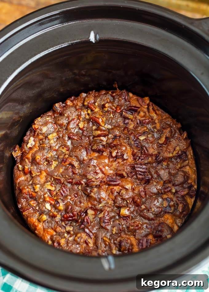 Velvety Slow Cooker Sweet Potatoes 3 Creamy Slow Cooker Sweet Potatoes Casserole cooking in a slow cooker, filling the kitchen with a sweet aroma.