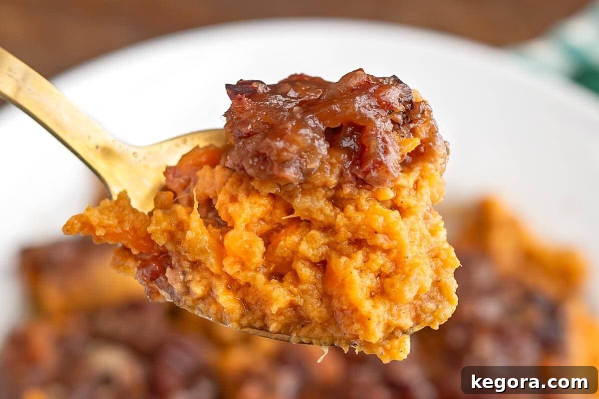 Velvety Slow Cooker Sweet Potatoes 4 Slow Cooker Candied Sweet Potatoes on a fork, showing the creamy texture and pecan topping.