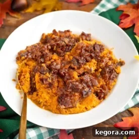 Velvety Slow Cooker Sweet Potatoes 6 Slow Cooker Candied Sweet Potatoes in white dish with a spoon.